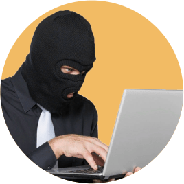 грабитель в маске-балаклаве сидит за компьютером